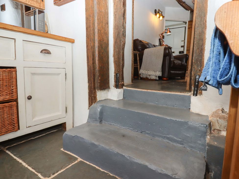 A hallway with staircase and cabinet at Carpenters Cottage in Okehampton
