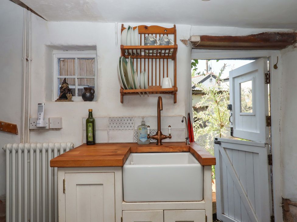 A kitchen with a wooden countertop and a sink at Carpenters Cottage Okehampton