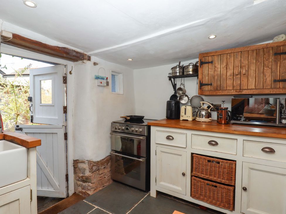 A kitchen with a stove and sink at Carpenters Cottage Okehampton