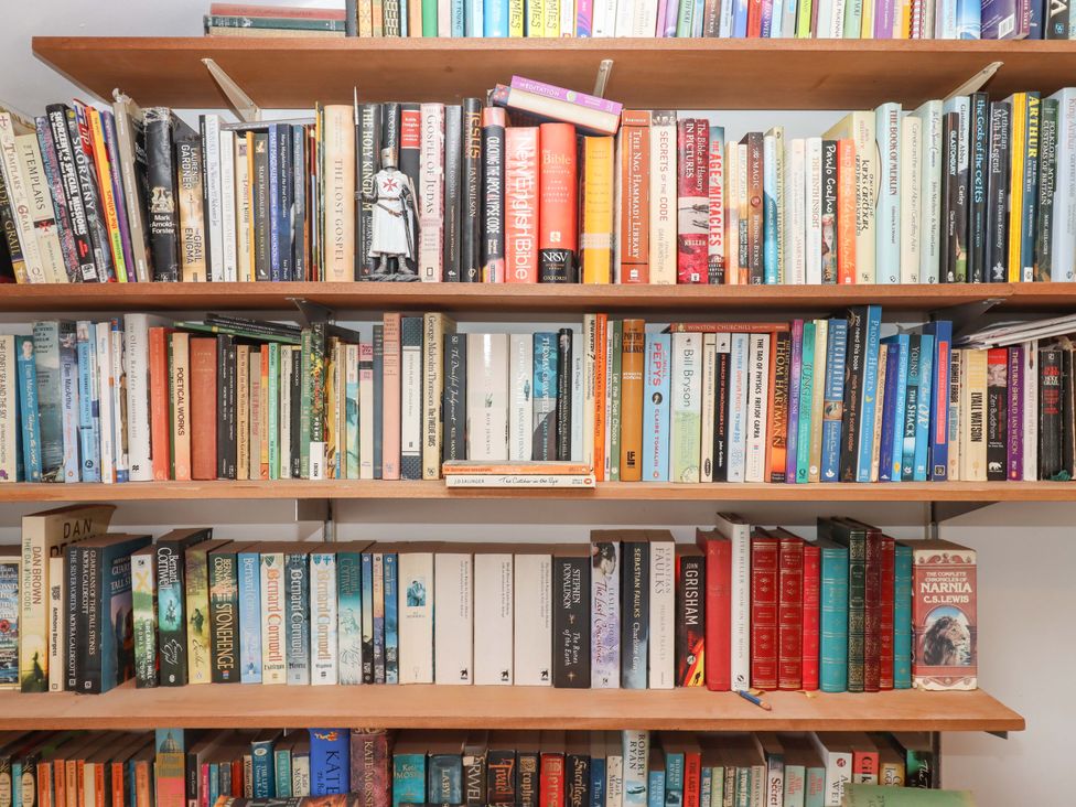 A bookshelf filled with various books at Carpenters Cottage Okehampton