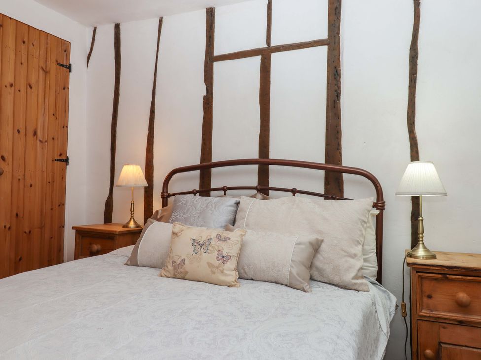 A bedroom with a bed and nightstands at Carpenters Cottage Okehampton