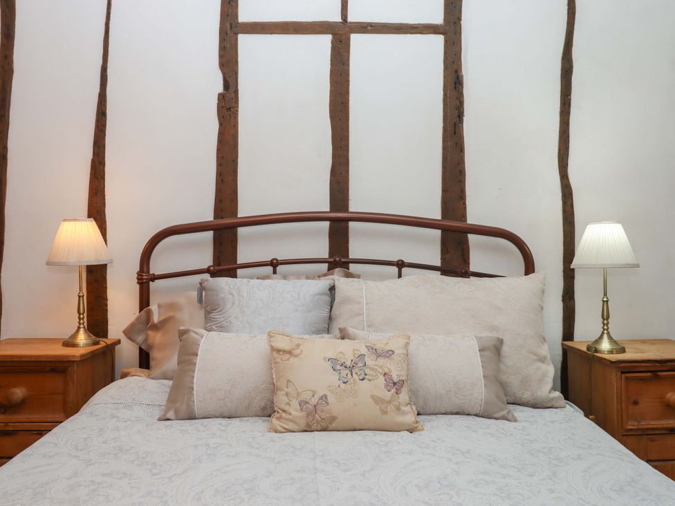 A bedroom with a bed and bedside lamps at Carpenters Cottage in Okehampton