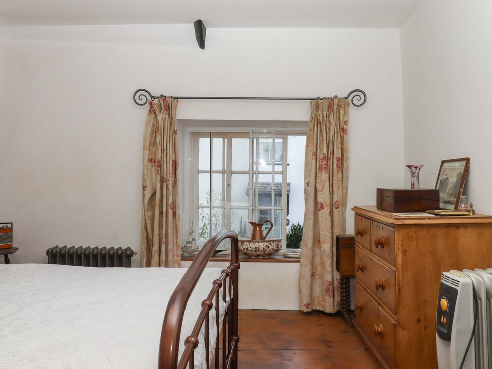 A bedroom with a bed and window at Carpenters Cottage Okehampton