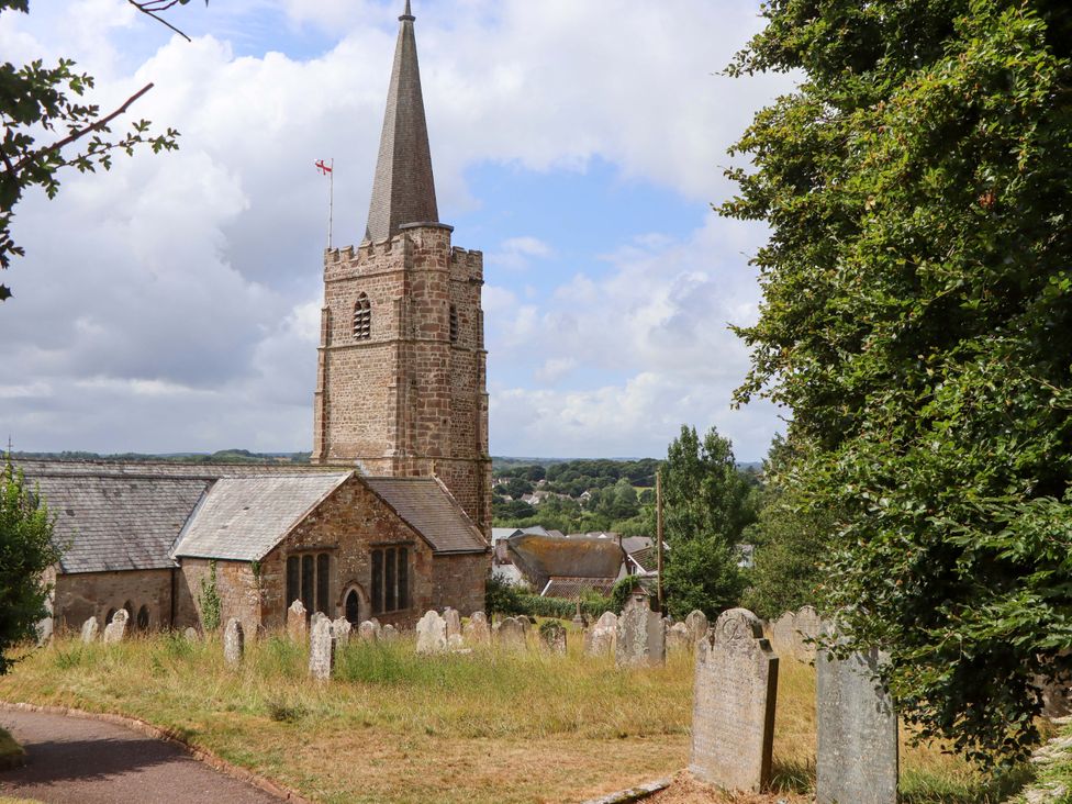 A church with a graveyard and tombstones at Carpenters Cottage in Okehampton