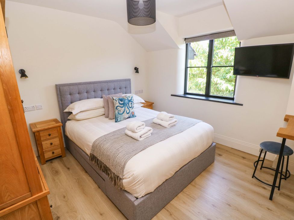 A bedroom with a bed and television at Just A Cottage in St Florence