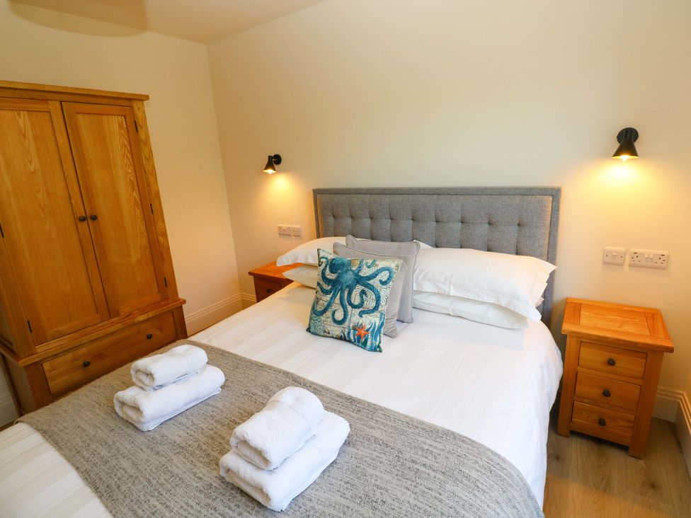A bedroom with a bed and wardrobe at Just A Cottage in St Florence