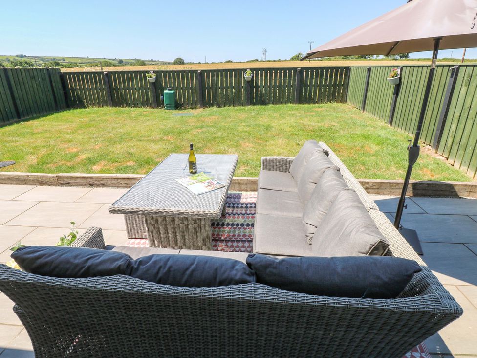 A garden with a sofa and coffee table at Just A Cottage St Florence