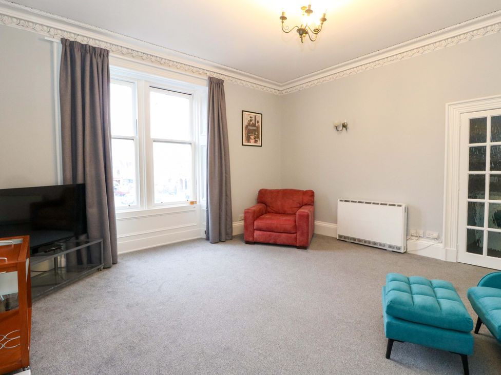 A living room with a sofa and television at 9A Market Square