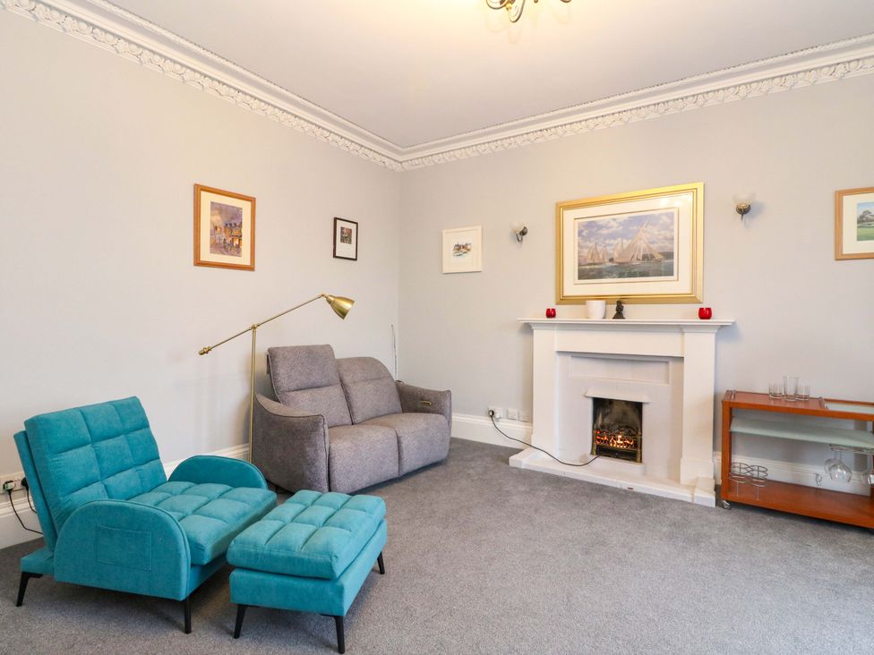 A living room with a fireplace and seating area at 9A Market Square