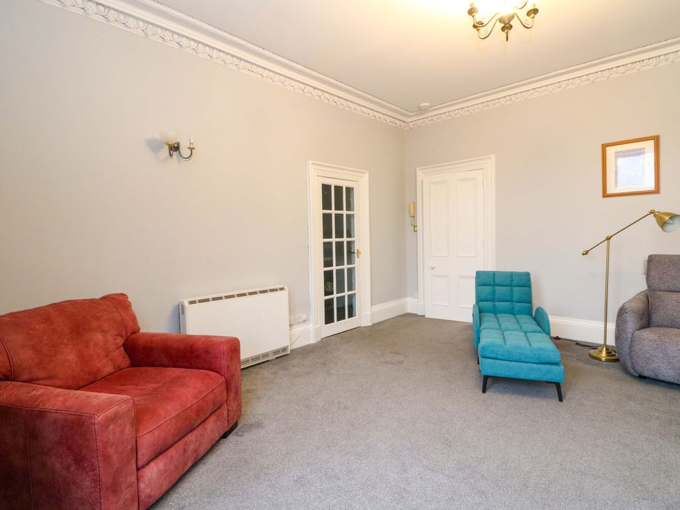 A living room with a red sofa and a blue chaise longue at 9A Market Square