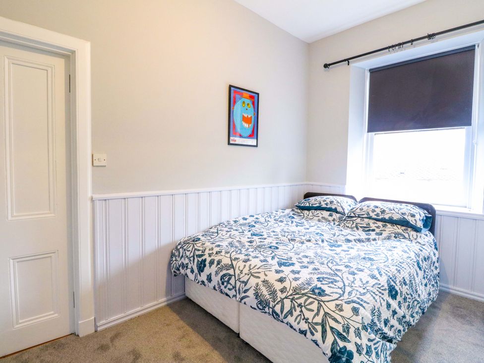 A bedroom with a bed and wall art at 9A Market Square