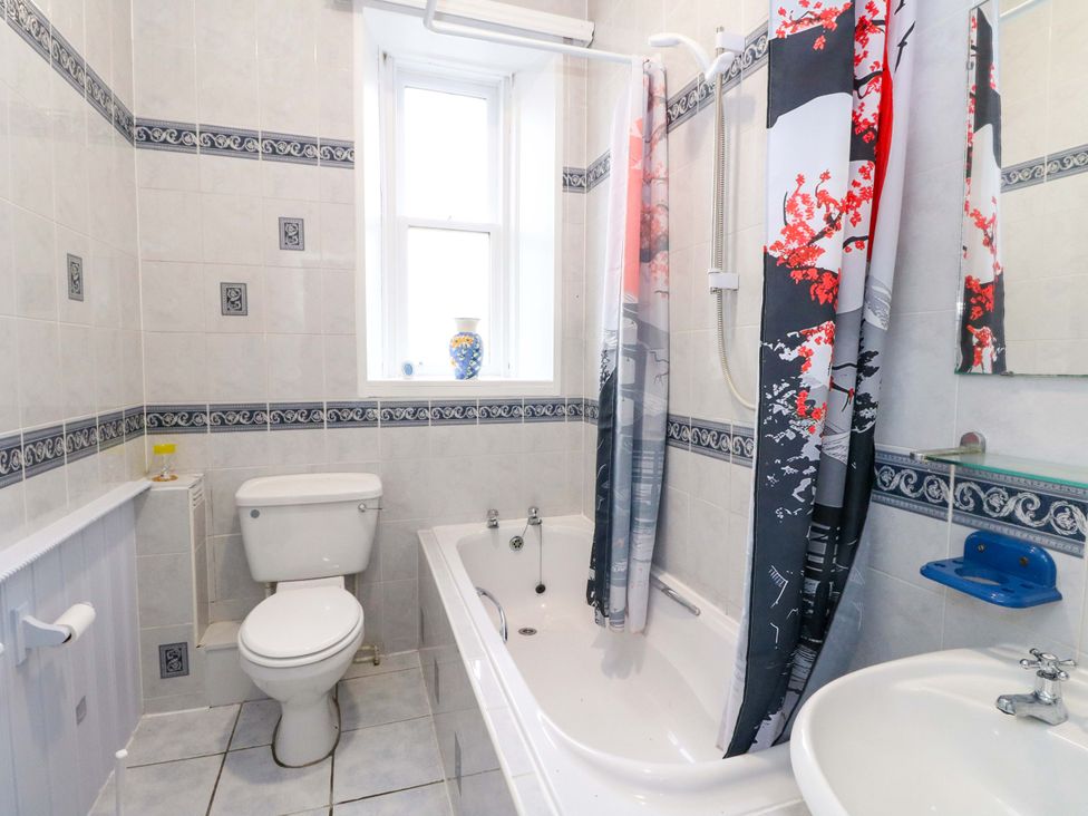 A bathroom with a toilet, bath, and sink at 9A Market Square