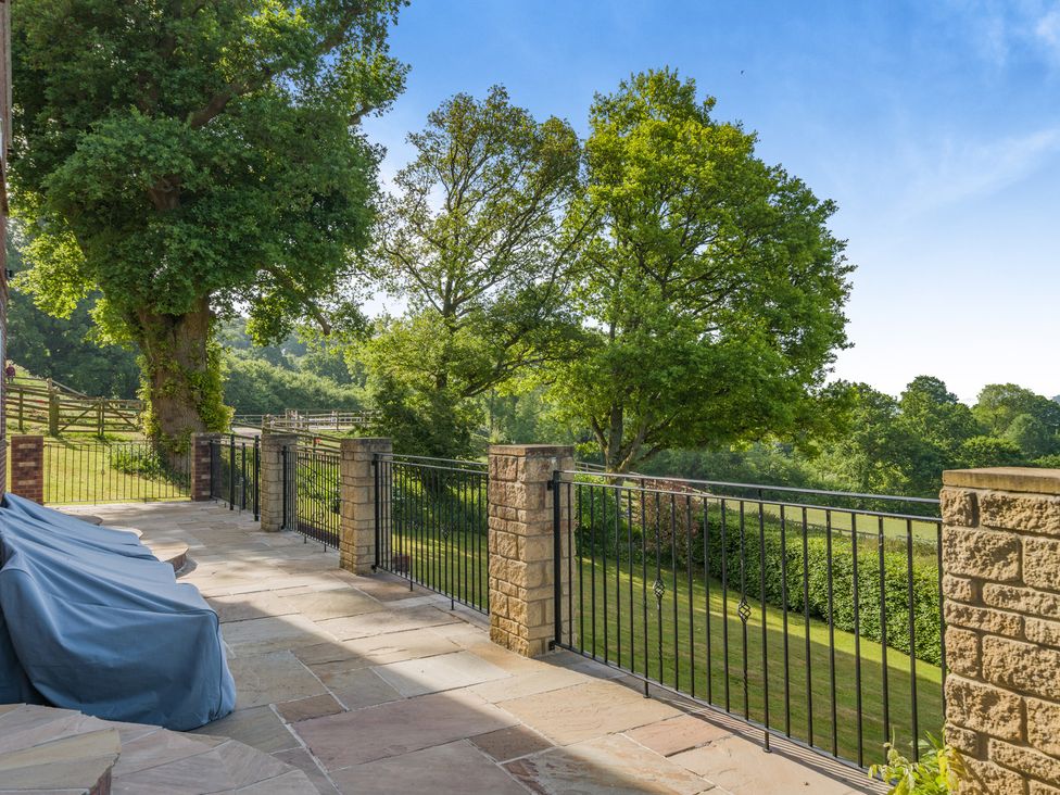 An outdoor area with a patio and trees at Underhill House