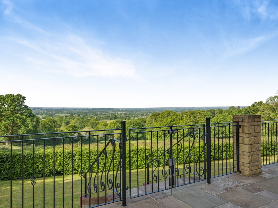 A view from a fenced outdoor area with hills and trees at Underhill House