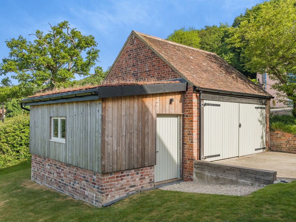 A garage with wooden panel and brick wall at Underhill House