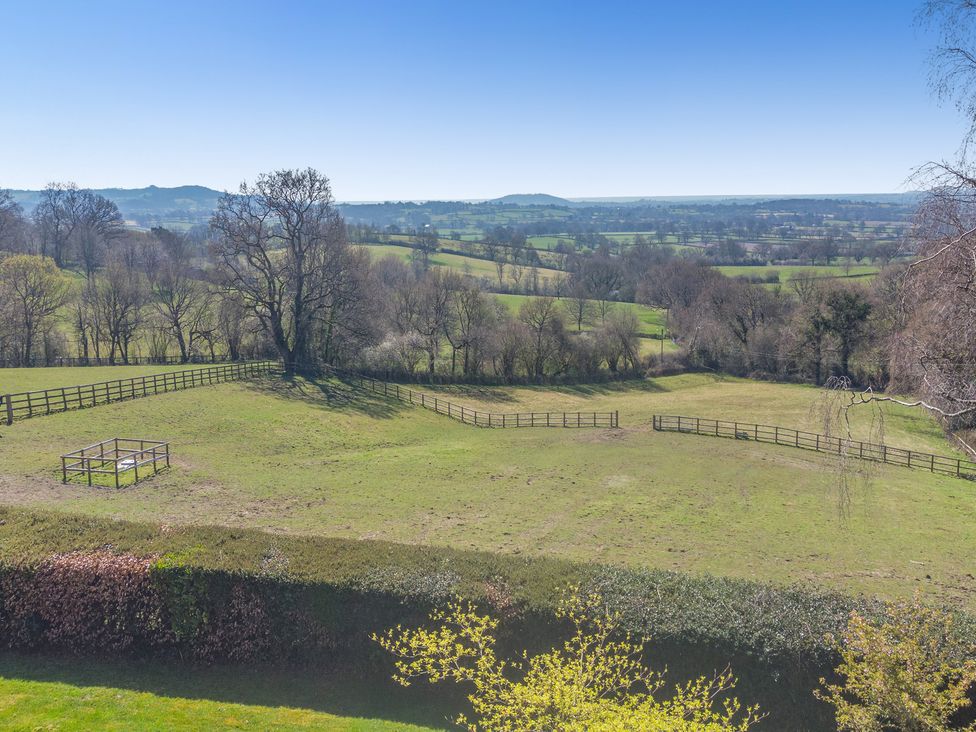 A view of a field with trees and a fenced area at Underhill House