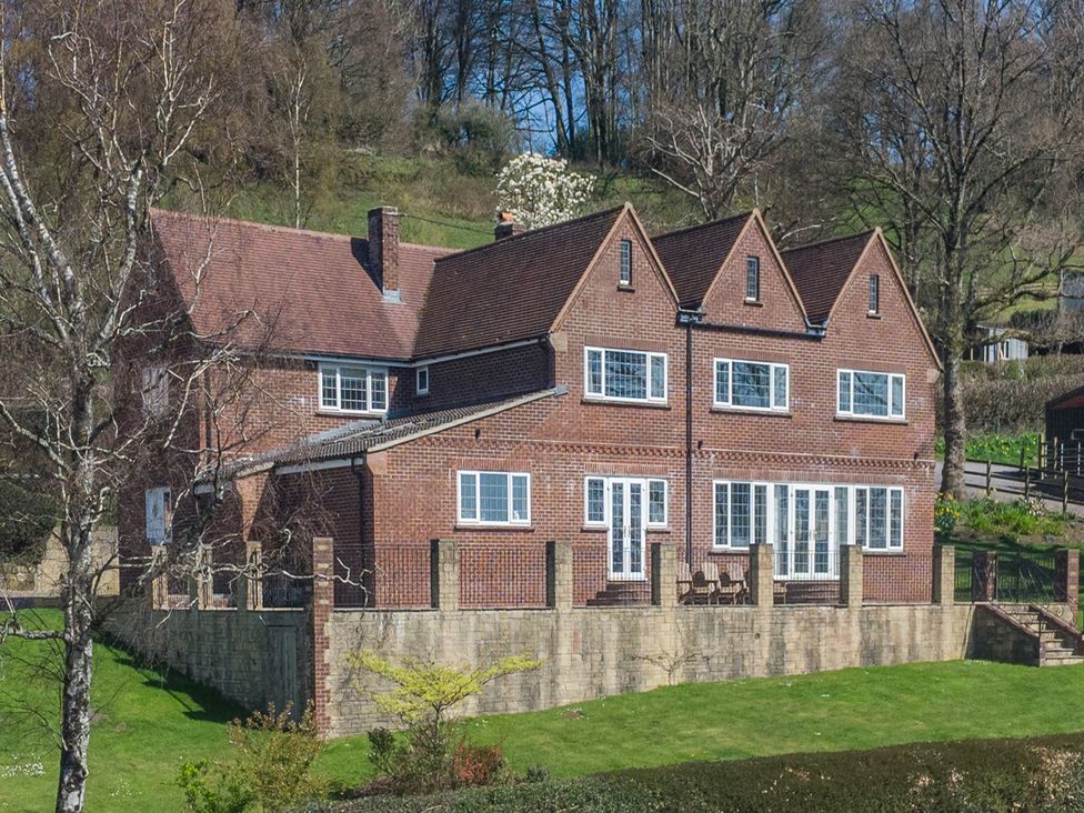 A house with multiple windows and doors in a garden at Underhill House