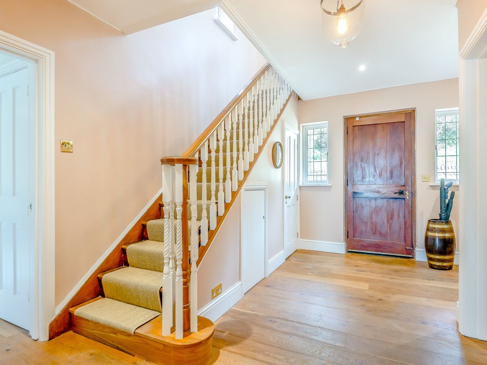 A hallway with a staircase and a front door at Underhill House 