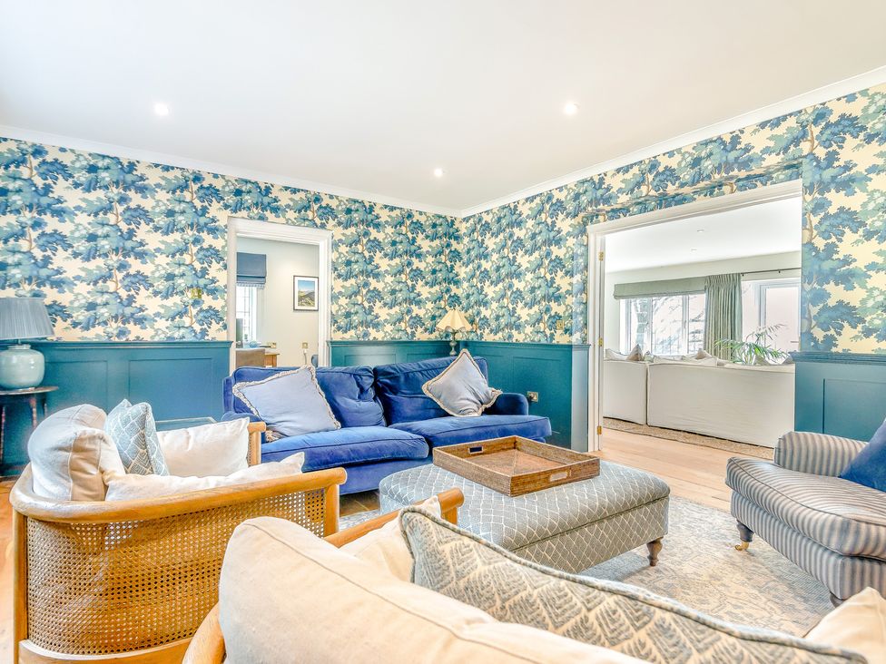 A living room with blue sofas and a wooden coffee table at Underhill House 