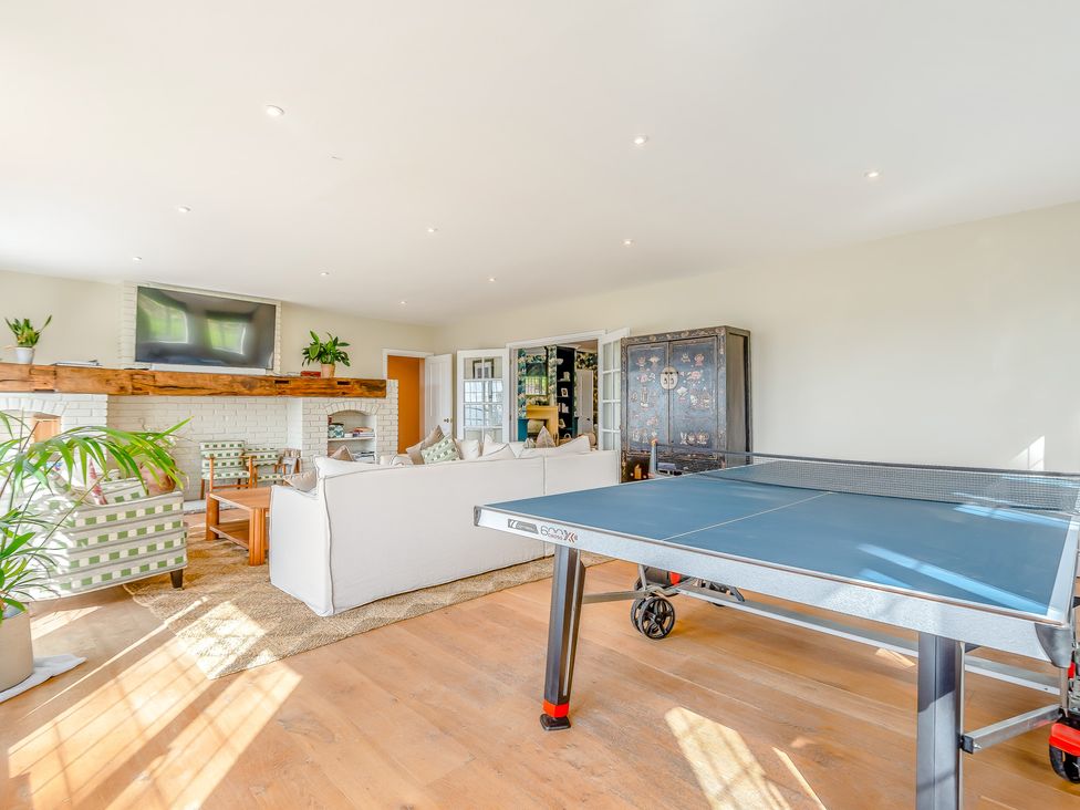 A living room with a ping pong table and a sofa at Underhill House