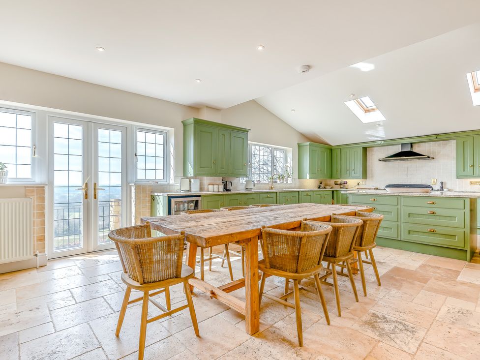 A kitchen with green cabinets and a dining table at Underhill House