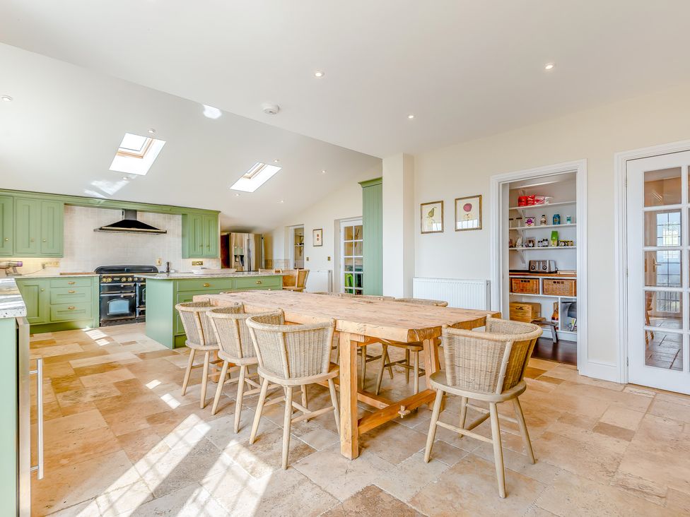 A kitchen with a dining table and chairs at Underhill House