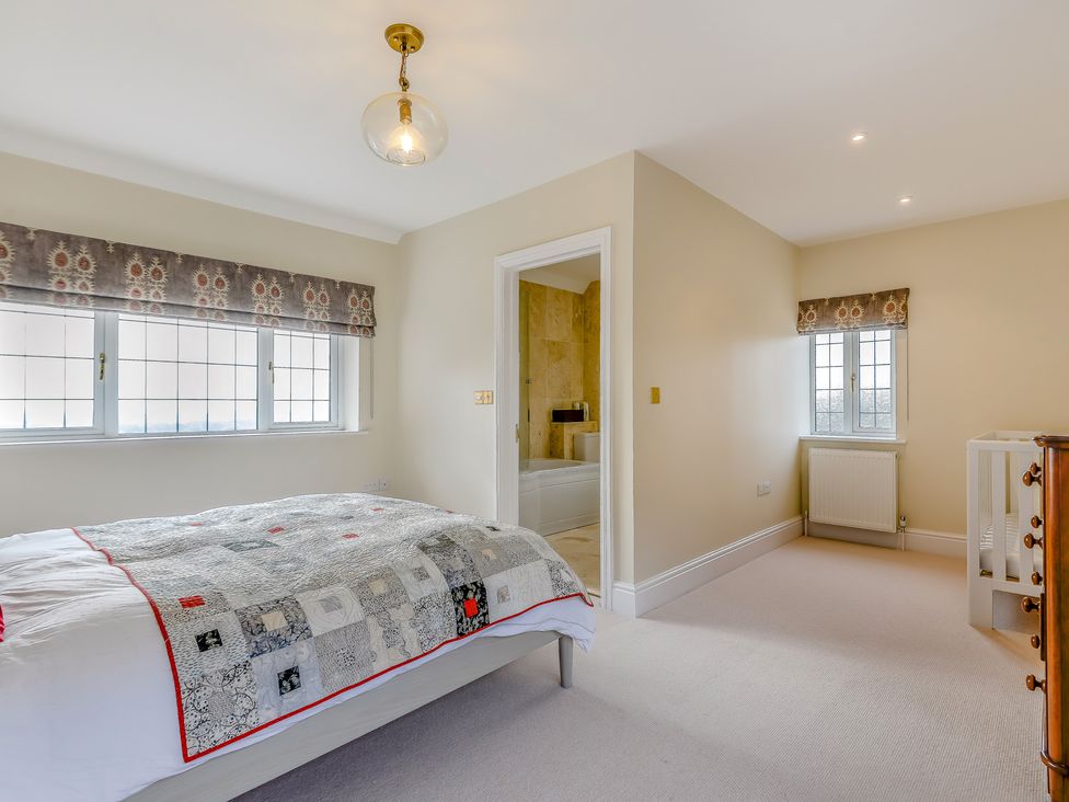 A bedroom with a bed and windows at Underhill House