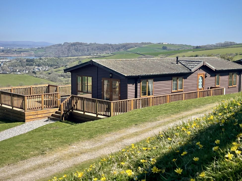 A lodge with a deck and steps at Lowena Lodge Whitsand Bay Holiday Park near Millbrook