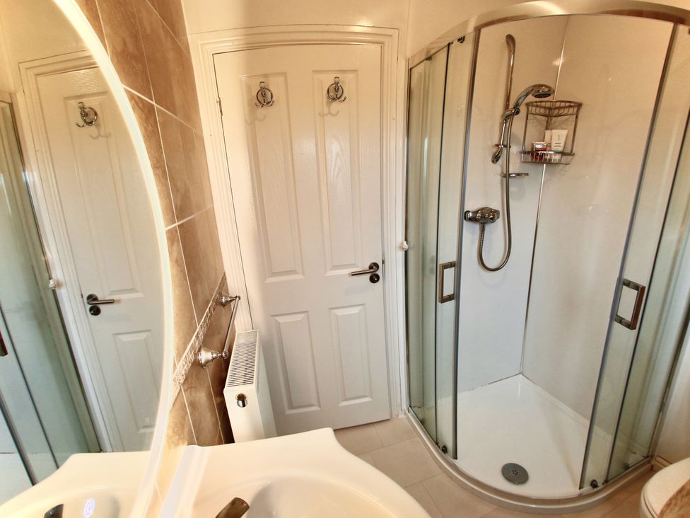 A bathroom with a shower and sink at Lowena Lodge Whitsand Bay Holiday Park near Millbrook