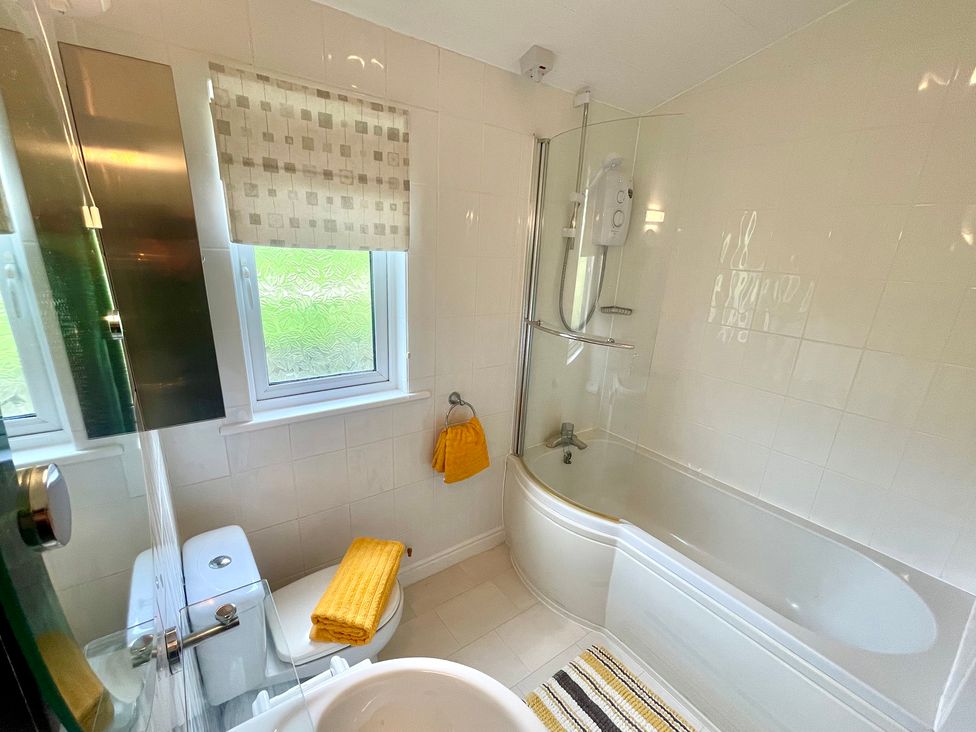 A bathroom with a bathtub, shower, and toilet at Lowena Lodge Whitsand Bay Holiday Park near Millbrook