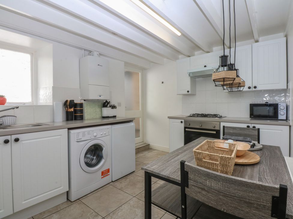 A kitchen with washing machine and microwave at 3 York Place in Conwy