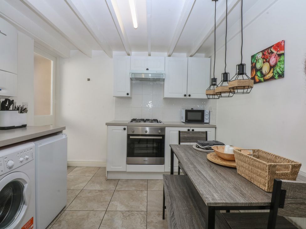 A kitchen with appliances and a dining area at 3 York Place Conwy