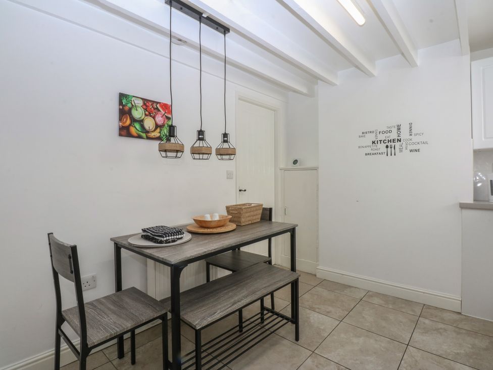 A kitchen with dining table and chairs at 3 York Place Conwy