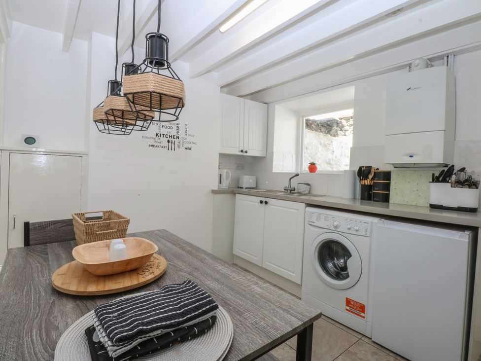 A kitchen with appliances and dining table at 3 York Place in Conwy