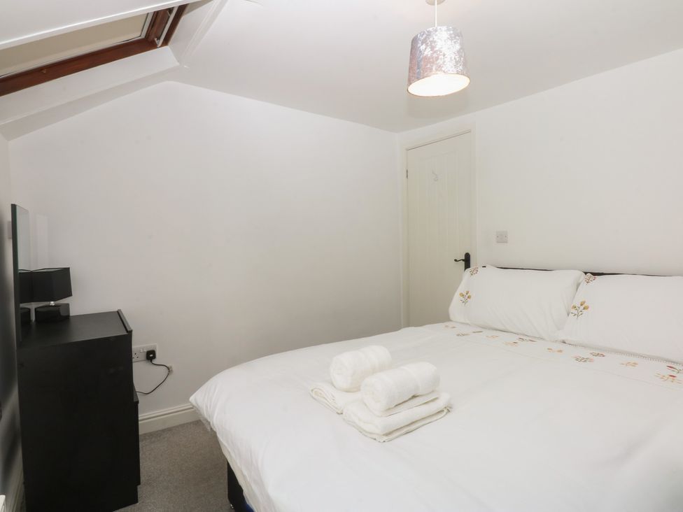 A bedroom with a bed and towels at 3 York Place in Conwy