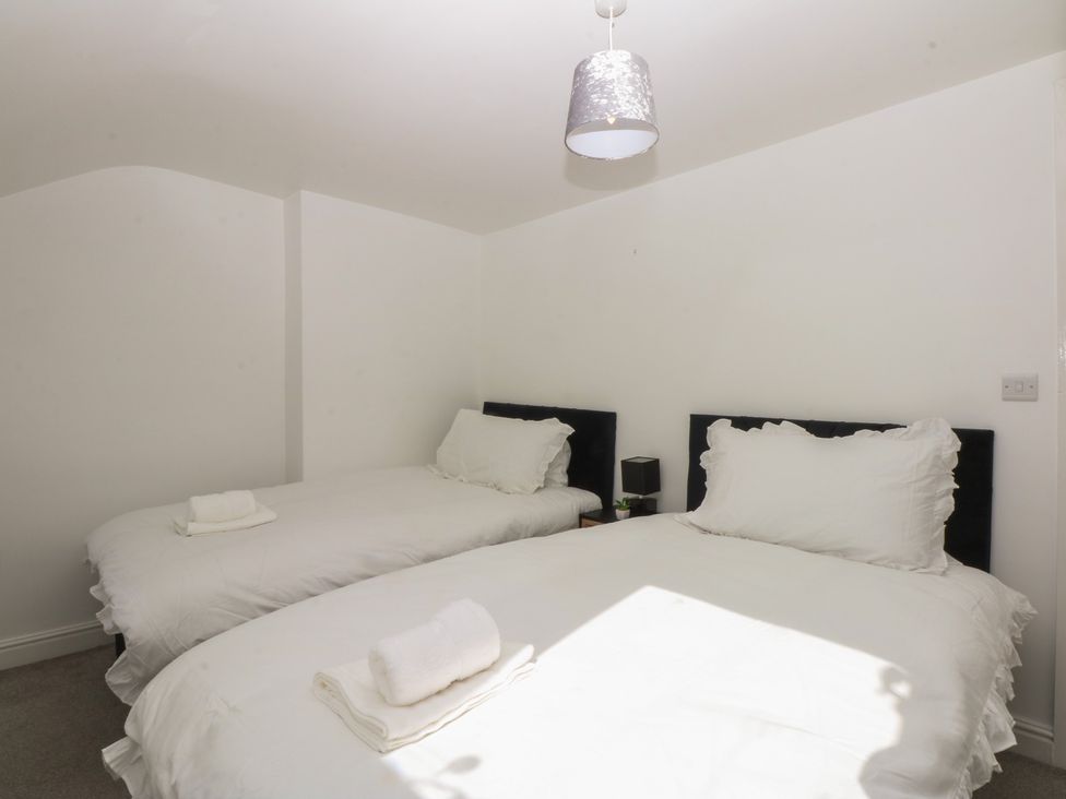 A bedroom with two beds and a light fixture at 3 York Place in Conwy