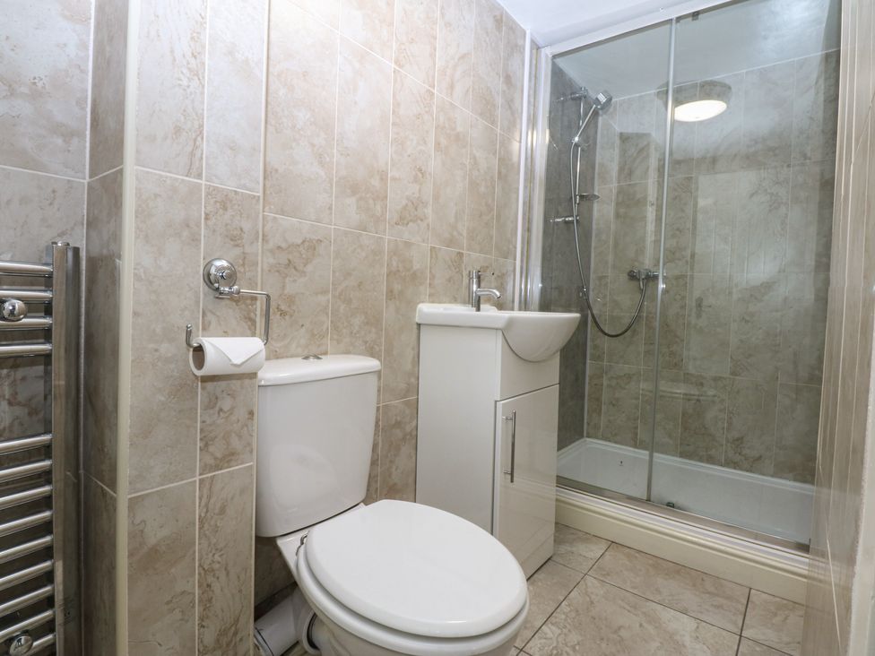 A bathroom with a shower, toilet, and sink at 3 York Place Conwy