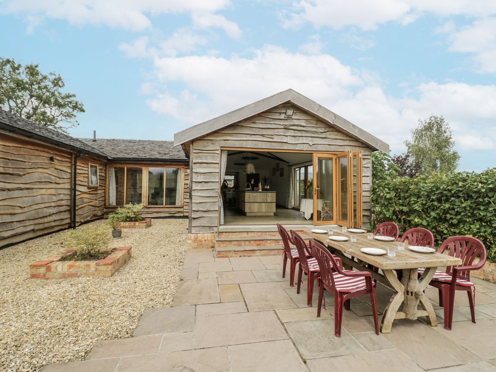 An outdoor dining area with a table and chairs at Owl Barn in Banbury