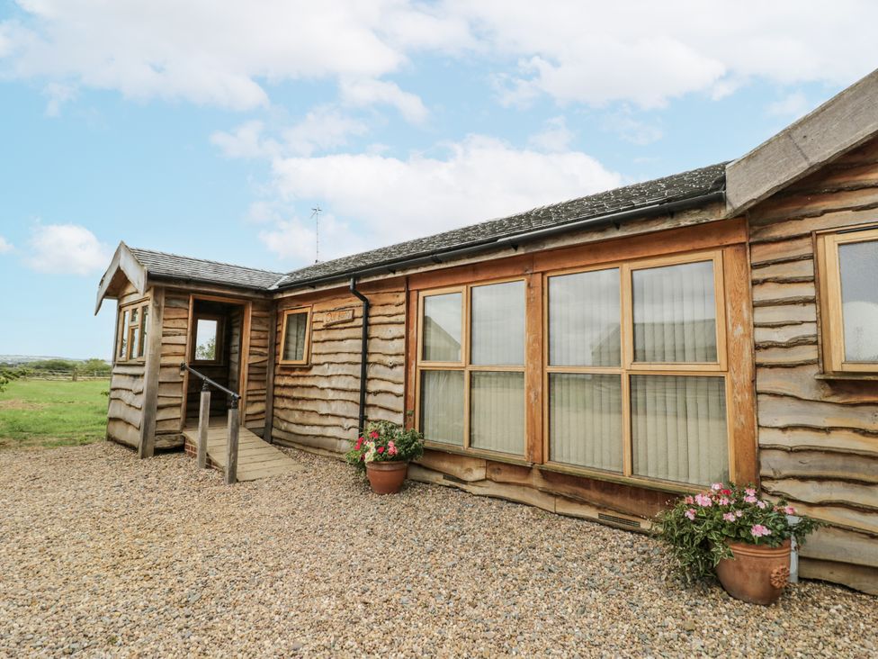 A wooden building with windows and a door at Owl Barn in Banbury