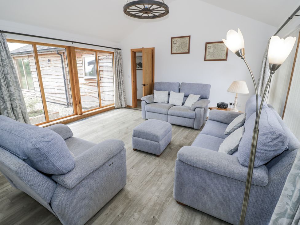 A living room with sofas and a window at Owl Barn in Banbury