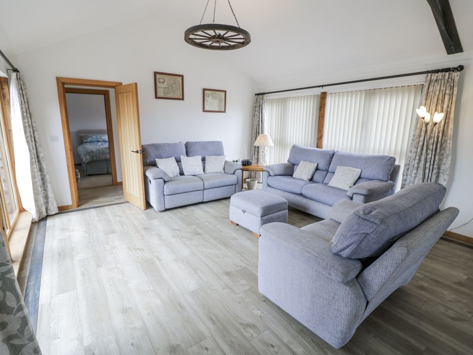 A living room with sofas and a footstool at Owl Barn in Banbury