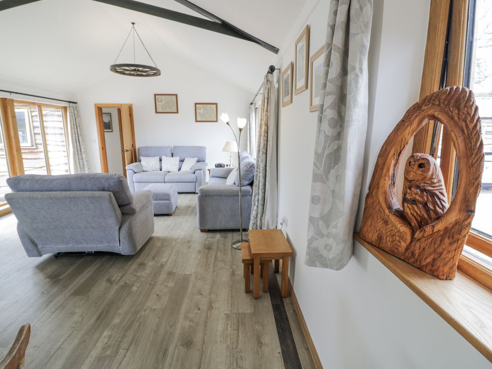 A living room with sofas and an owl sculpture at Owl Barn in Banbury