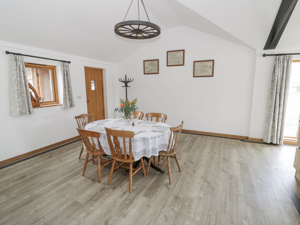 A dining room with a table and chairs at Owl Barn in Banbury