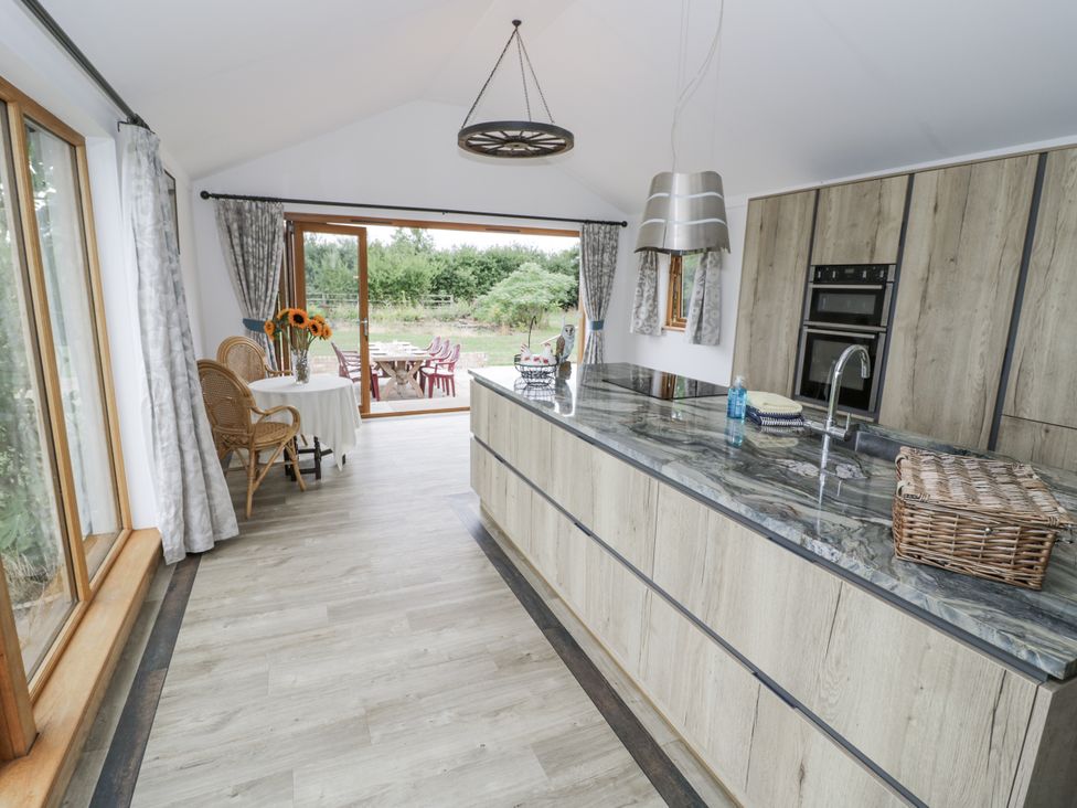 A kitchen with an island and dining setup at Owl Barn in Banbury