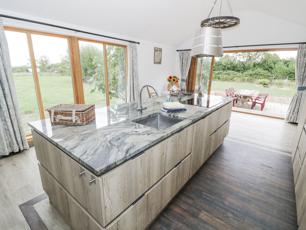 A kitchen with a large island and sink at Owl Barn in Banbury