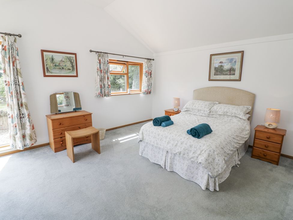 A bedroom with a bed and furniture at Owl Barn in Banbury