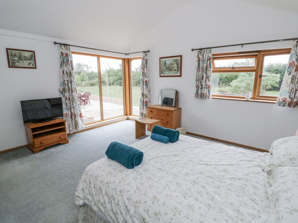 A bedroom with a bed and television at Owl Barn in Banbury