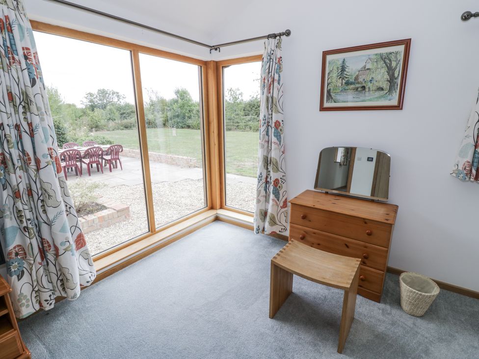 A bedroom with a dresser and mirror at Owl Barn in Banbury
