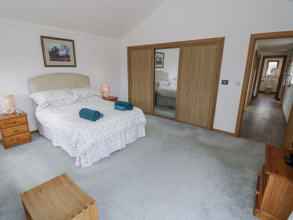 A bedroom with a bed and nightstand at Owl Barn in Banbury