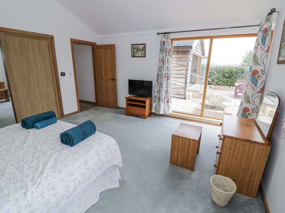 A bedroom with a bed and television at Owl Barn in Banbury